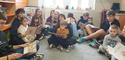 Na zdjęciu uczniowie kl. 8 czytający książki dzieciom z oddziału przedszkolnego. 